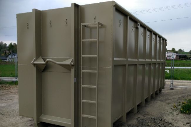 Detailaufnahme der grauen Abrollcontainer-Klappe mit angebrachter Leiter: Effiziente Lösung für Transport und Lagerung von Materialien und Abfällen